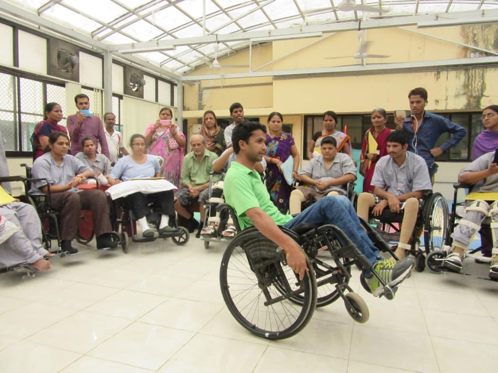 Mohammad Imran demonstrating two-wheel balance and wheelie techniques to wheelchair users in a Mumbai rehabilitation center