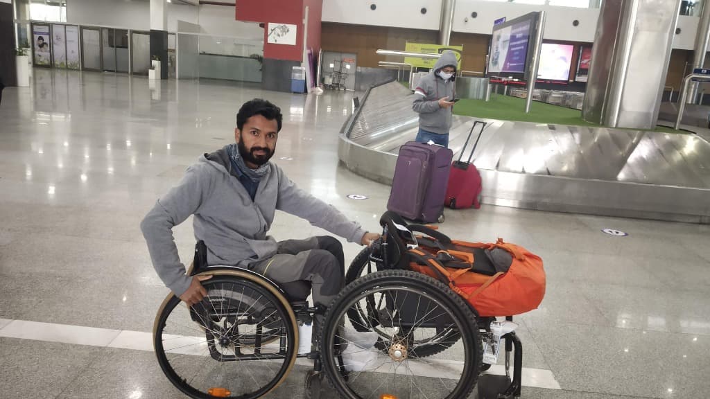 Mohammad Imran at airport arrival terminal with luggage and baggage carousel in background
